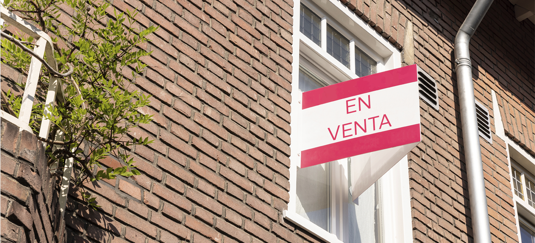 Cartel de venta en la ventana de un piso