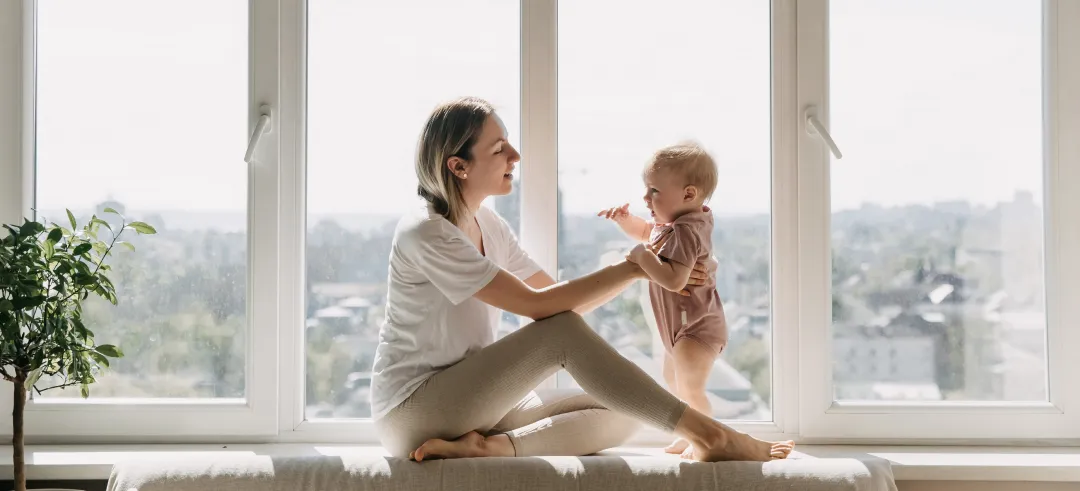 Madre poniendo de pie a su hijo en su casa