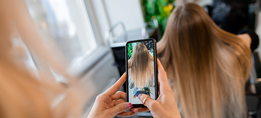 Peluquera sacando una foto del pelo de una clienta